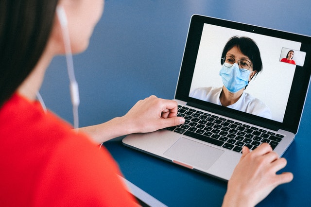 Imagem de mulher sendo atendida por médica em videochamada 
