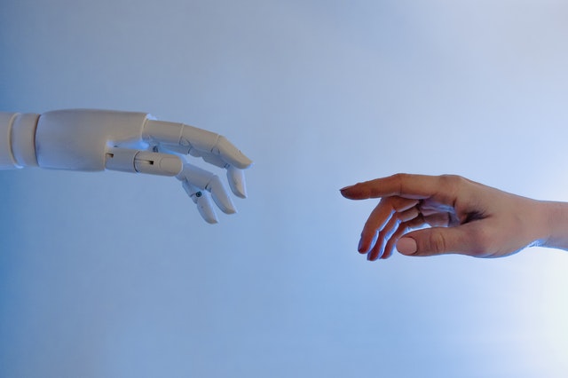 Imagem de mão humana indo ao encontro de mão robótica