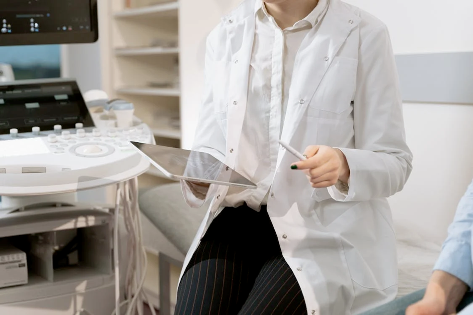 Uma médica olhando em um tablet o resultado do exame do paciente.